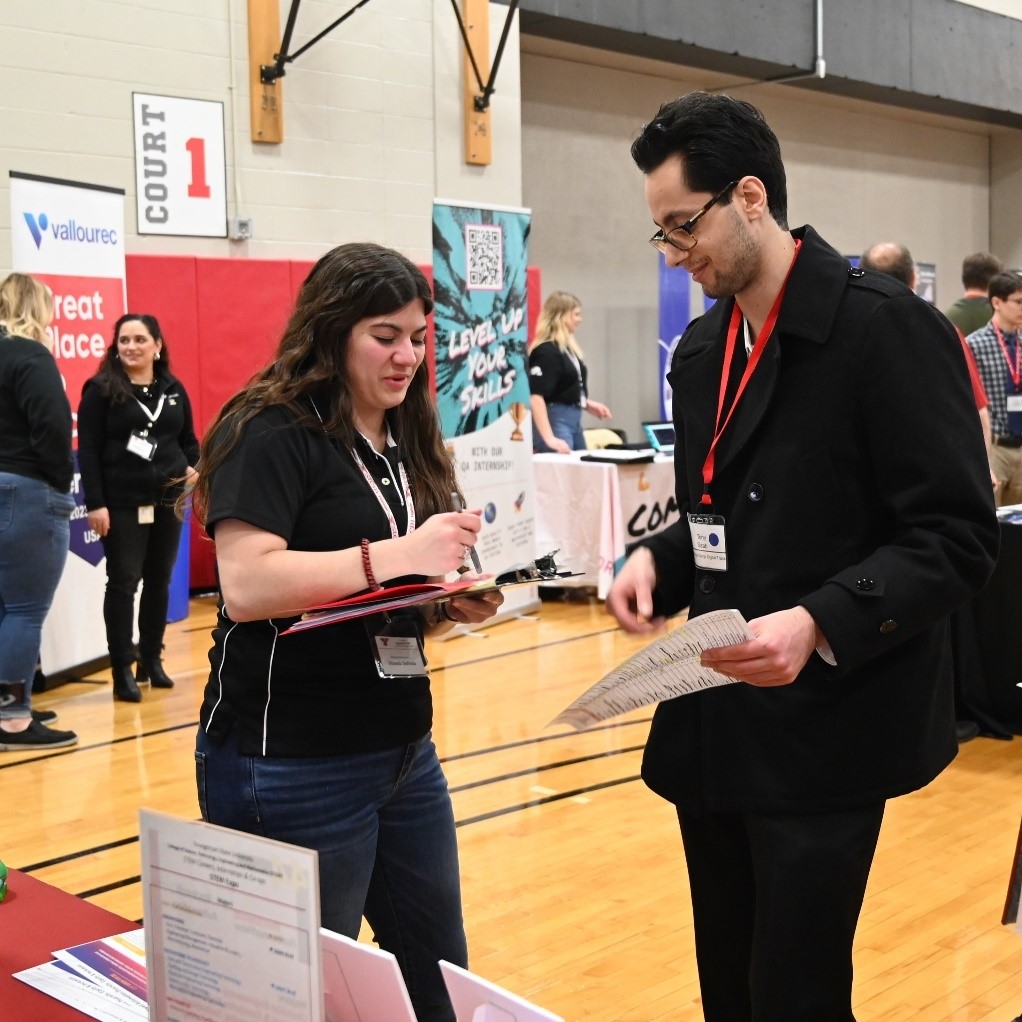 Student speaks to employer rep at Spring 2024 STEM Expo
