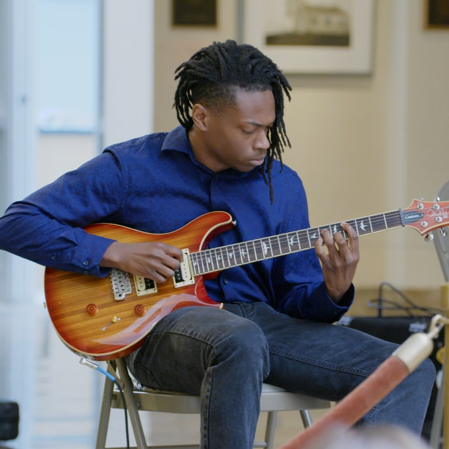 student holding a guitar