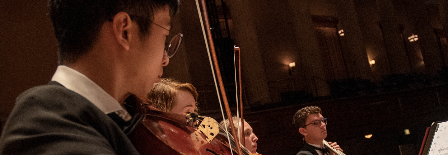violin student playing in orchestra