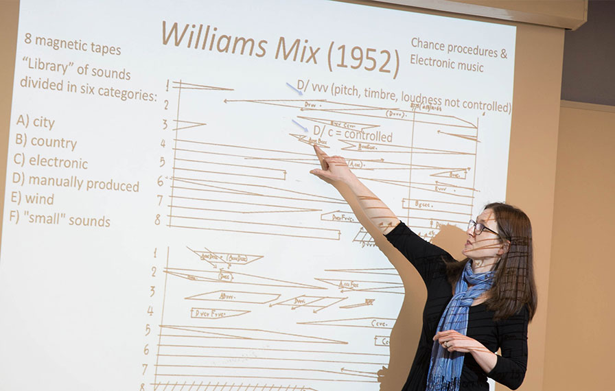 Music classroom. professor gesturing to projection of powerpoint slides