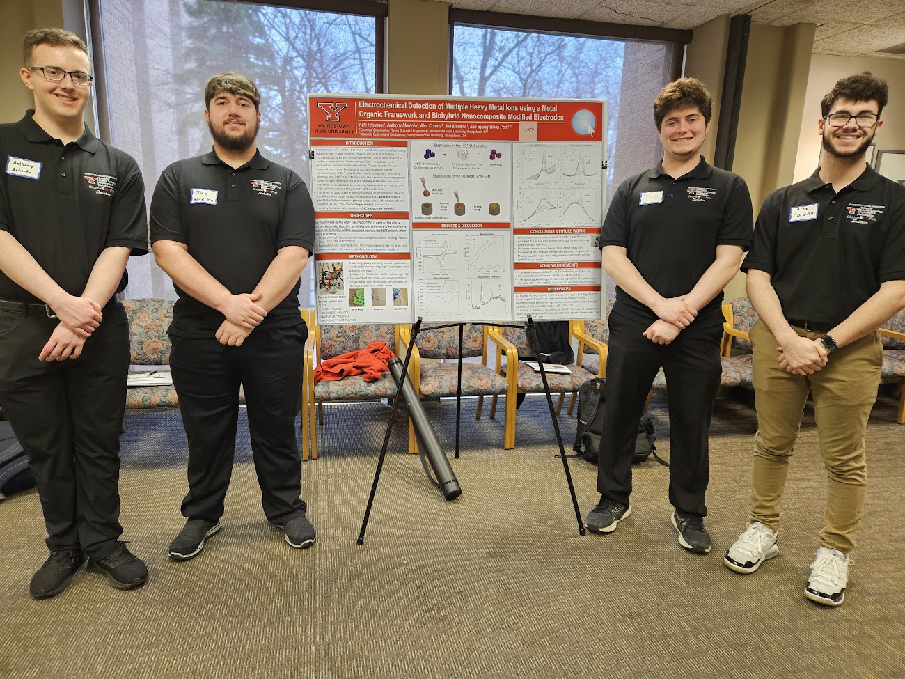 A research team poses by their research poster at QUEST