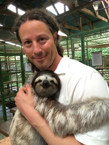 Dr. Michael Butcher poses with a sloth